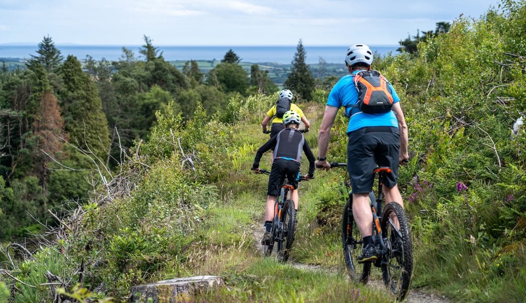 Three mountain bikers on the red trail at Castlewellan Forest Park near the Mourne Mountains